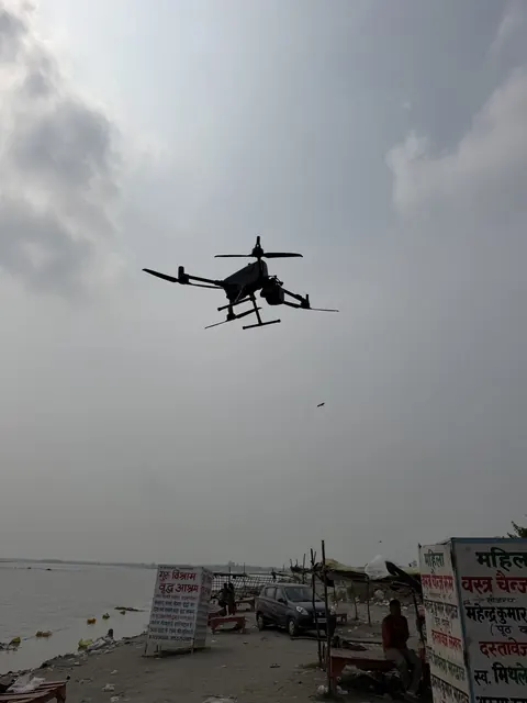 The Matrice 400 RTK over the ghat, with the Ganga and the ghat's signboards below